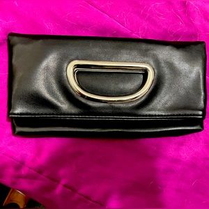Multifunctional foldable clutch in black faux leather.